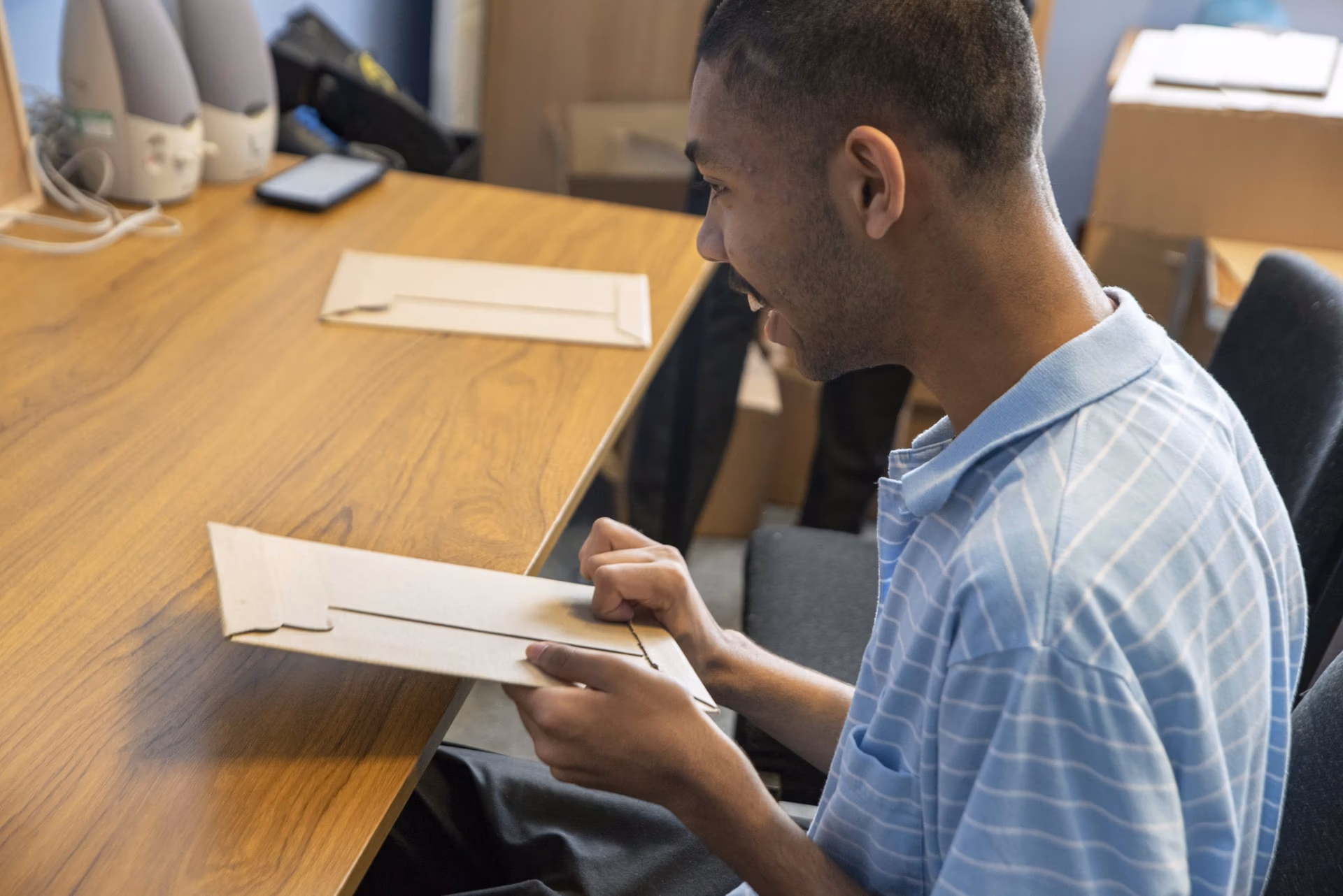a cardboard mailer with tactile features, a person using the tactile features
