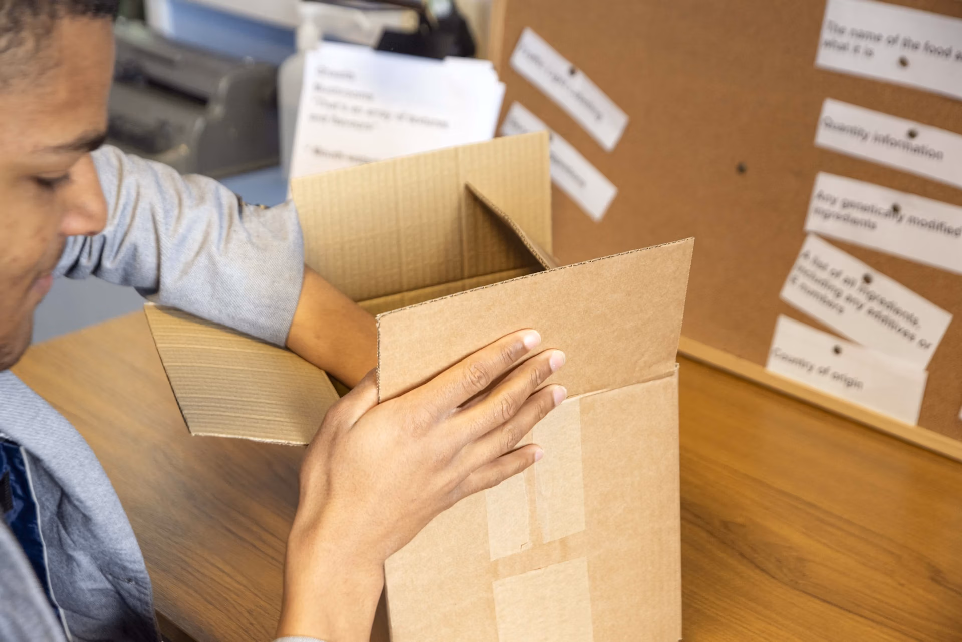 A cardboard box that has been opened, using tear strip paper tape