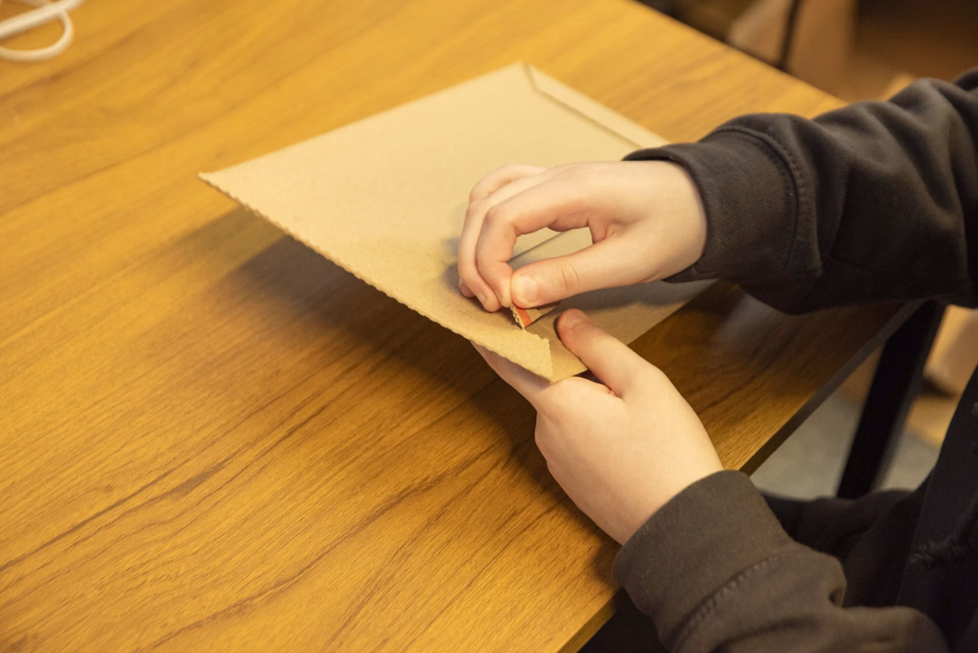 opening a cardboard mailer by the opening tab